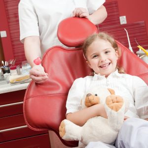 Happy girl in pediatric dental chair